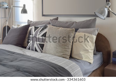 modern bedroom with gray pillow and lamp on wooden bedside table at home