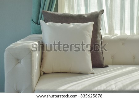 Black and white pillow on beige sofa with natural light in the living room