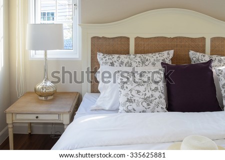 vintage bedroom interior with flower pillows and decorative table lamp