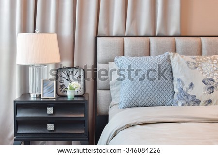 elegant bedroom interior design with floral pattern pillows and decorative table lamp.