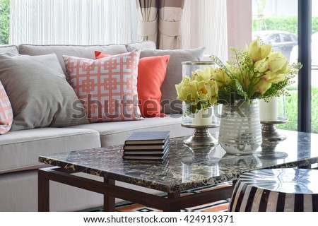 Books and decorative items on marble top table and lively sofa set