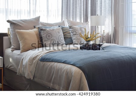 luxury bedroom interior design with striped pillows and decorative tea set on bed