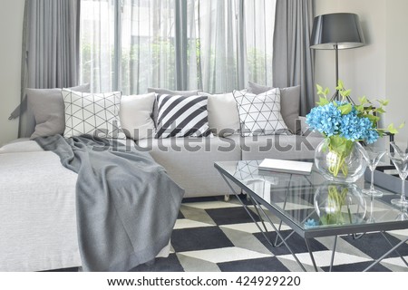 Light gray L shape sofa set with varies pattern and color pillows in modern living room