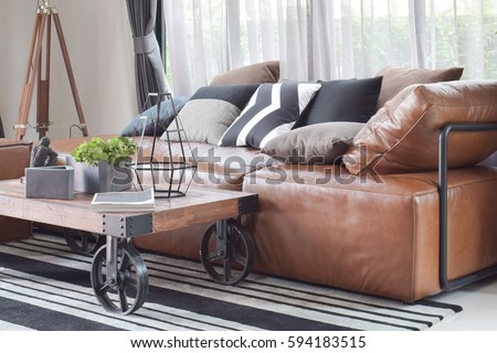 Wood center table with wheel and light brown leather sofa in industrial style decoration