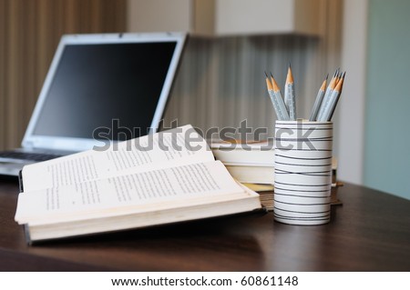 work table with computer notebook,pencil, book in a home