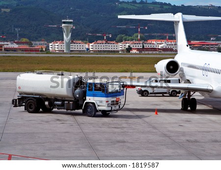 Truck refueling an airplane on the airport