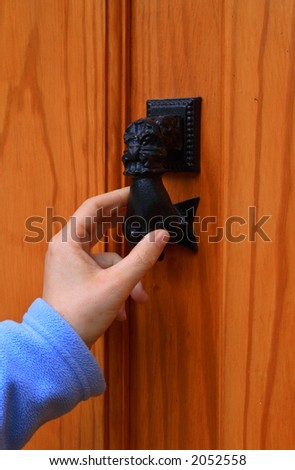 A woman knocking on the door of a house