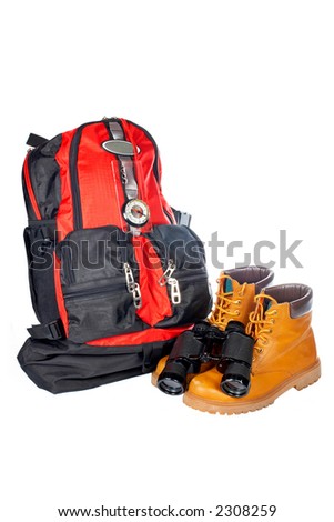 Hiking boots, compass, binoculars and backpack over a white background
