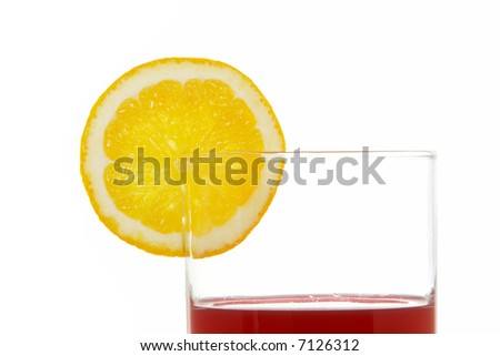 A glass of red juice with a lemon slice, reflected on white background