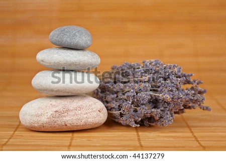 Stack of balanced stones and flower with shallow depth of field