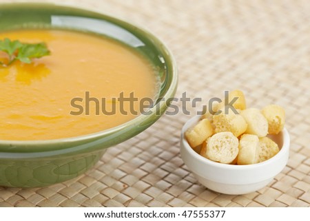 Cream of spinach soup with parsley and bread croutons on wooden background. Shallow depth of field