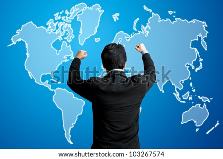 Successful business man raising hand in front of virtual world map screen
