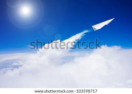 Paper plane flying over clouds against blue sky