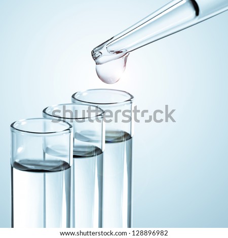 Liquid drop from laboratory glass pipette to test tube