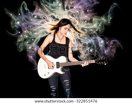 Young and beautiful rock girl playing the electric guitar with fantasy smoke and glitter star