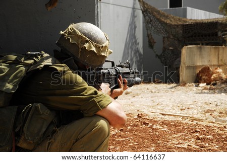 Israeli infantry soldier looking around the corner in an urban drill in the army. This is part of regular training that every soldier does.