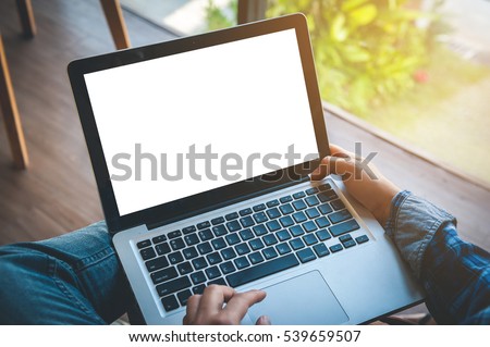 Cropped image of a young man working on his laptop in a coffee shop, rear view of business man hands busy using laptop at office desk, typing on computer sitting at wooden table