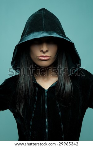 A portrait of a glamorous model wearing a dress with hood and glossy lipstick.