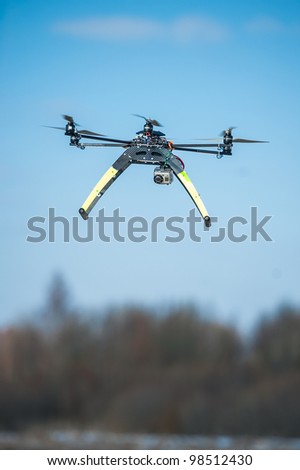 Modern radio controlled helicopter or Hexa copter with camera in flight with blue sky background