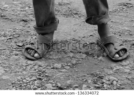 feet of poor boy covered with mud