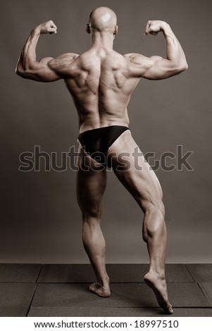 a muscular young man posing artistic, back double biceps