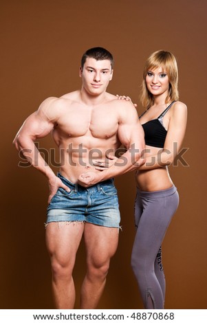 fitness couple: young man wearing short pants with blond fitness young woman