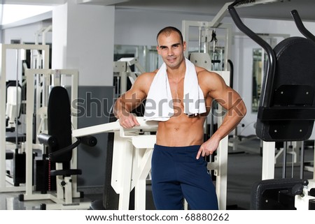 young caucasian bodybuilder in the gym smiling, with a towel around his neck