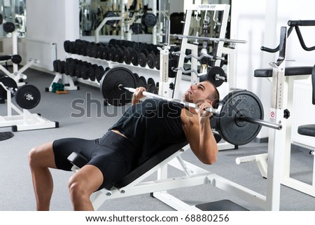 young bodybuilder training in the gym: chest - barbell incline bench press - wide grip