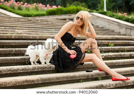 young fashion woman in the park with her dog