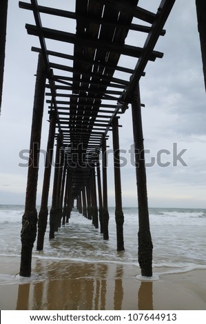 Wooden Bridge on the beach with waves and refection - vertical image