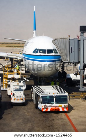 Aircraft tow tractor standing by for push back.