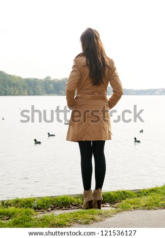 lonely young woman on lake, rear view