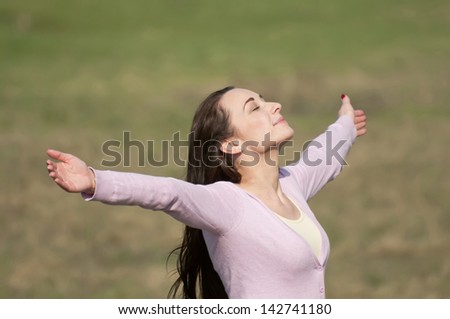 young woman feeling free with arms wide open