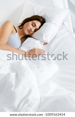 Sleep. Young Woman Sleeping In Bed. Portrait Of Beautiful Female Resting On Comfortable Bed With Pillows In White Bedding In Light Bedroom In Morning. People Sleep. High Quality Image.