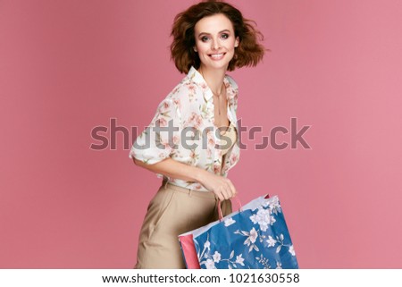 Fashion. Woman With Shopping Bags In Fashionable Clothes  On Pink Background. Happy Smiling Young Female Model In Stylish Clothing Holding Colorful Paper Bags. Women Style. High Quality Image.