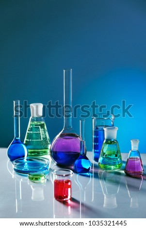 Laboratory Glass With Colorful Liquid. Close Up Of Laboratory Transparent Glassware With Multicolor Fluid On Table In Chemical Lab. Laboratory Equipment. Chemical Research. High Quality Image.