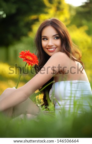Beautiful Woman With Gerbera Flower Enjoying Nature against Nature Background