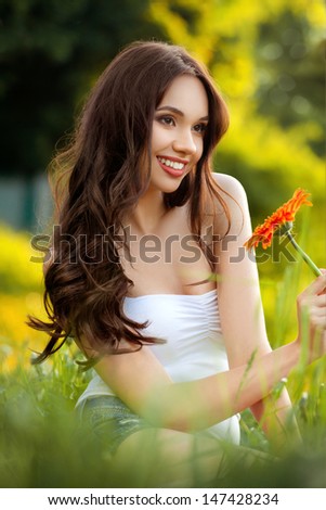 Beautiful Woman With Gerbera Flower Enjoying Nature against Nature Background