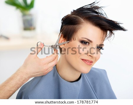 Hair. Hairdresser Cutting Woman's Hair in Beauty Salon. Haircut