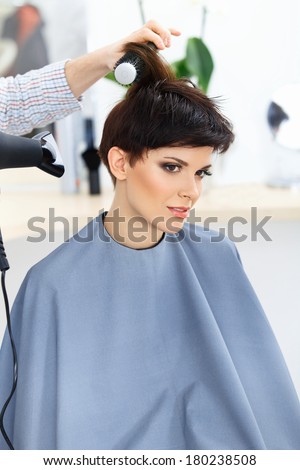 Hairdresser Using Dryer on Woman Wet Hair. Brunette with Short Hair in Hair Salon.