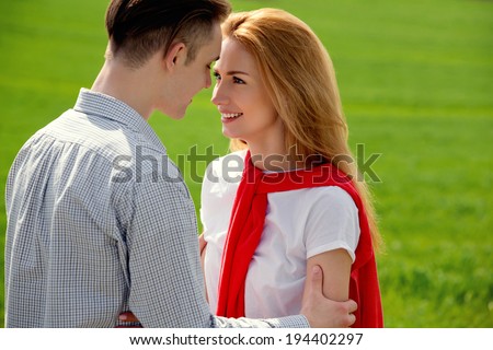 Kissing couple in love. They are smiling and looking at each other.