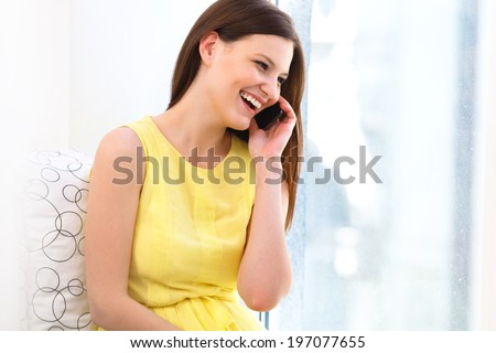 Portrait of a laughing young woman talking on mobile phone