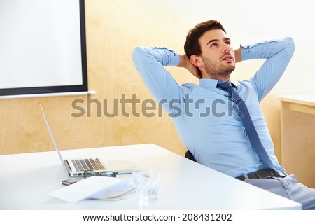 Portrait of a relaxed young businessman sitting in a bright office