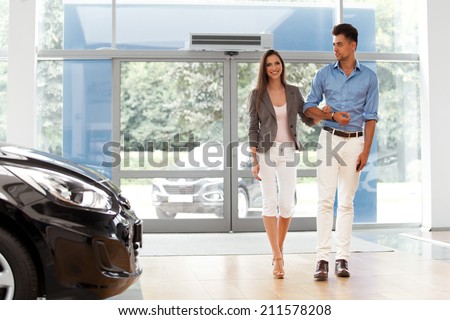 Young Couple Came into the Car Showroom. Auto Salon