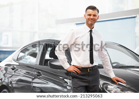 Salesman standing in car retail store. Car Showroom.