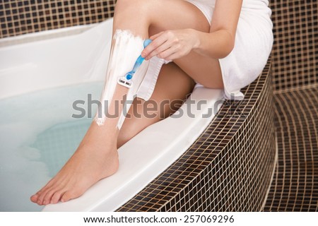 Long Woman Legs . Woman Shaving Legs in Bathroom