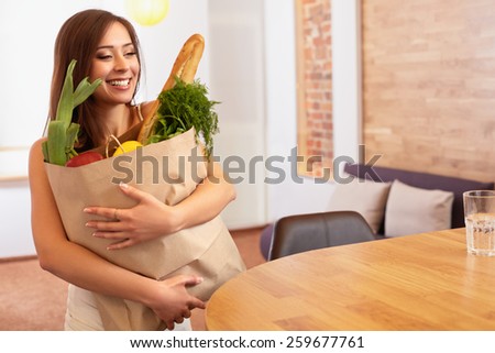 Woman Holding Shopping Bag With Vegetables Standing in the Kitchen