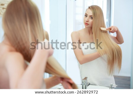 Hair. Beautiful Blond Brushing Her Hair. Hair Care. Spa Beauty Model
