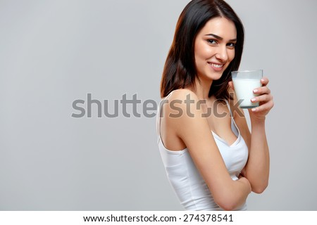 Happy young woman drinking milk