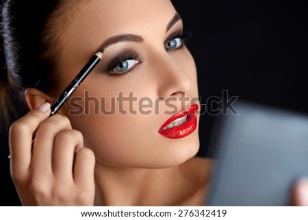 Make-up. Beautiful Woman Doing Makeup Eyebrow Pencil. Red Lips
